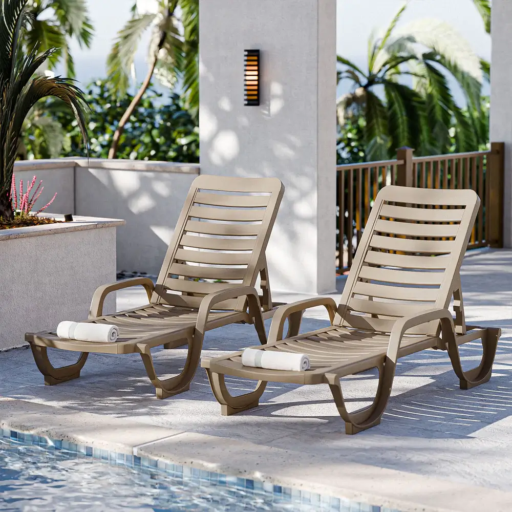 Two Bahia commercial chaises in French Taupe arranged beside a resort pool, creating a relaxing and sophisticated poolside retreat.